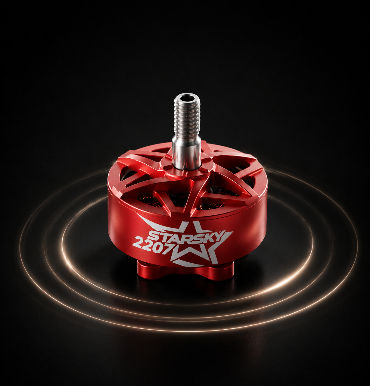 A red brushed aluminum brushless motor with a silver threaded shaft, featuring the 'zenirace 2207' model name printed in white on the side. The motor is centered on a black background with glowing gold concentric rings emanating from its base.