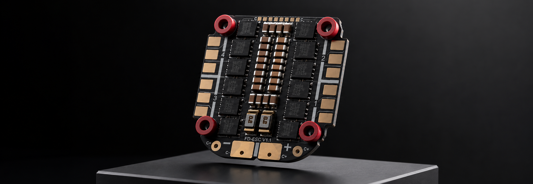 A high-performance FPV flight controller board with gold and black components, red mounting rings, and a black PCB, displayed on a dark gray pedestal against a black background.