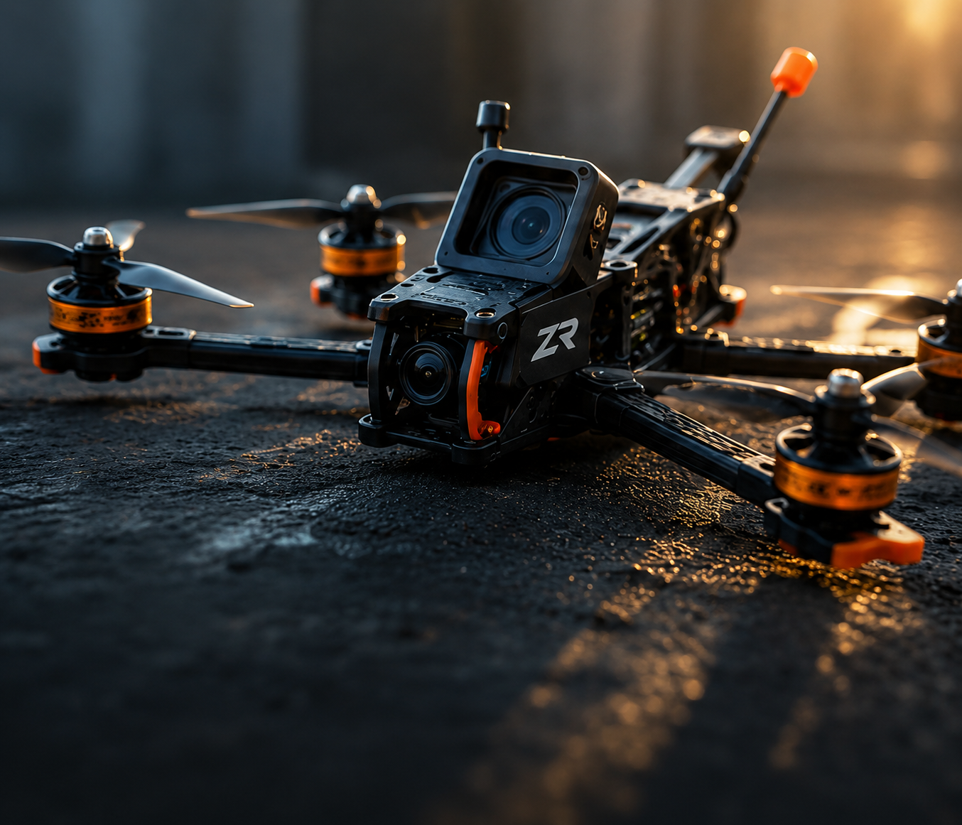 A close-up of a black quadcopter drone with orange accents and a mounted camera, resting on a dark textured surface with dramatic golden-hour lighting.